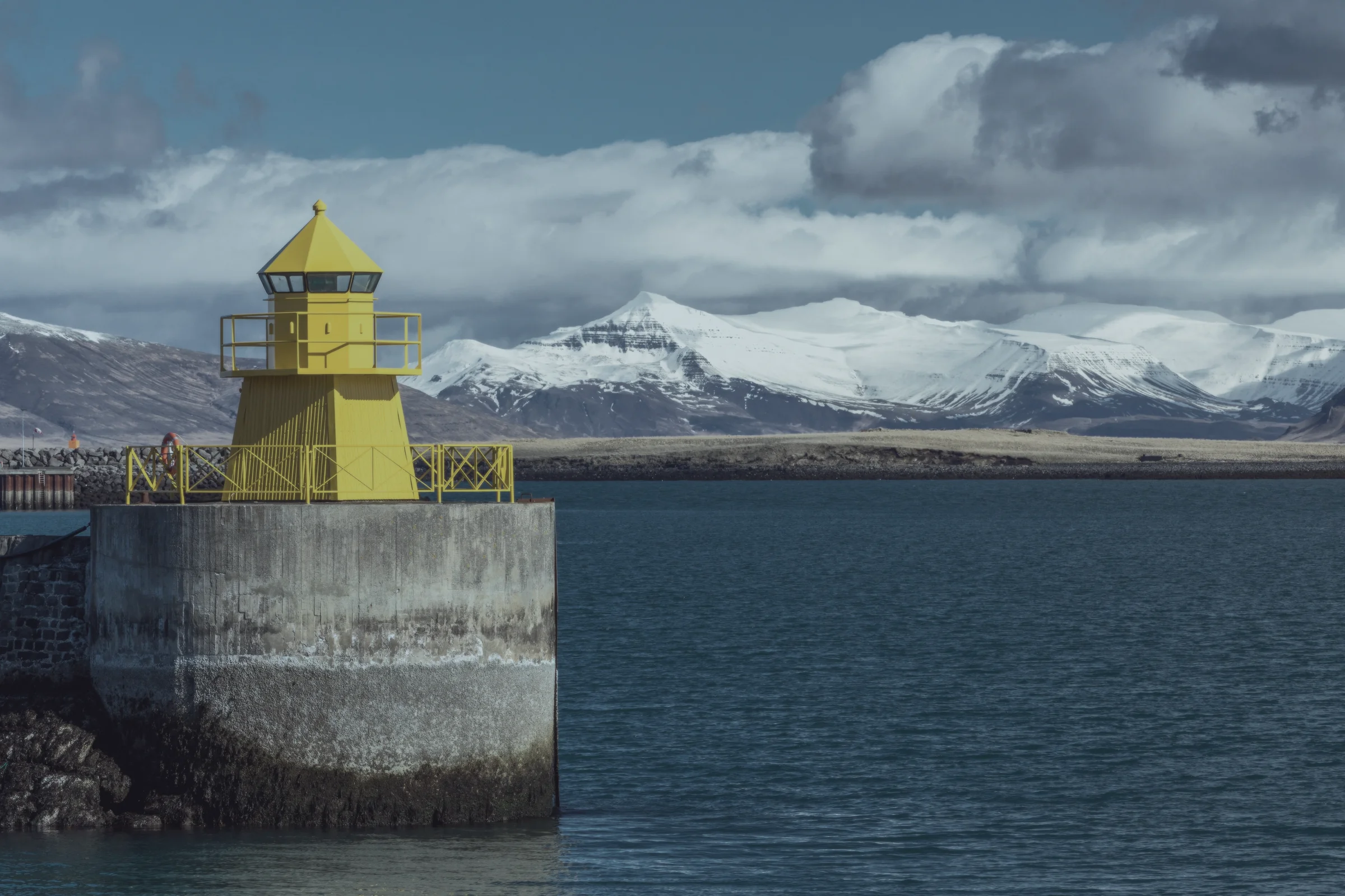 Reykjavík harbour lighthouse with snow-capped mountains